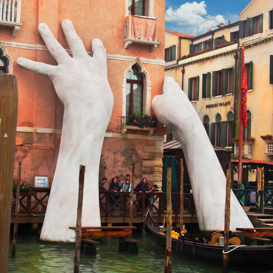 Giant hands reach out of Venice’s Grand Canal with Italian sculptor Lorenzo Quinn's "Support" — photo by Charla Jones.
